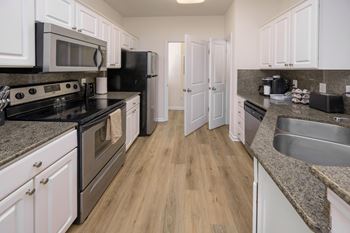 A kitchen with black appliances and white cabinets.